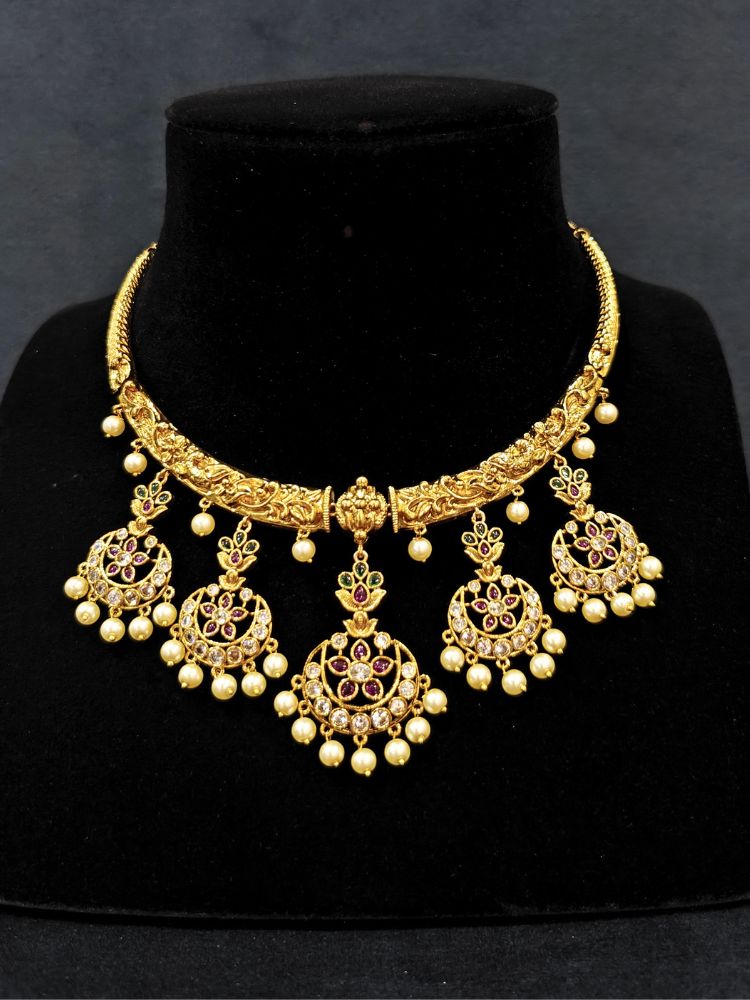 Close-up of an ornate traditional (Gold Polish) Hasli Collar Jewellery Set and Earrings with American Diamond, Colored Stones and Pearls. Woman wearing lightweight artificial American Diamond Hasli jewelry for long wedding functions. Woman wearing Hasli American Diamond artificial jewelry for a grand celebration.