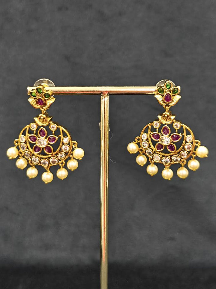 Close-up of an ornate traditional (Gold Polish) Hasli Collar Jewellery Set and Earrings with American Diamond, Colored Stones and Pearls. Woman wearing lightweight artificial American Diamond Hasli jewelry for long wedding functions. Woman wearing Hasli American Diamond artificial jewelry for a grand celebration.