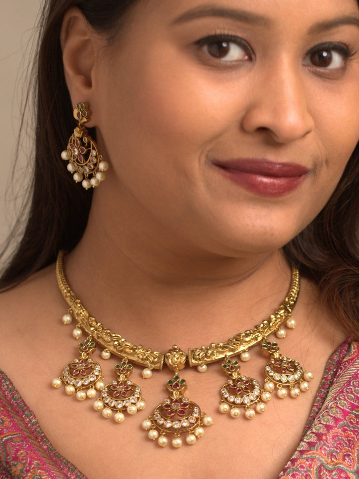 Close-up of a women wearing an ornate traditional (Gold Polish) Hasli Collar Jewellery Set and Earrings with American Diamond, Colored Stones and Pearls. Woman wearing lightweight artificial American Diamond Hasli jewelry for long wedding functions. Woman wearing Hasli American Diamond artificial jewelry for a grand celebration.