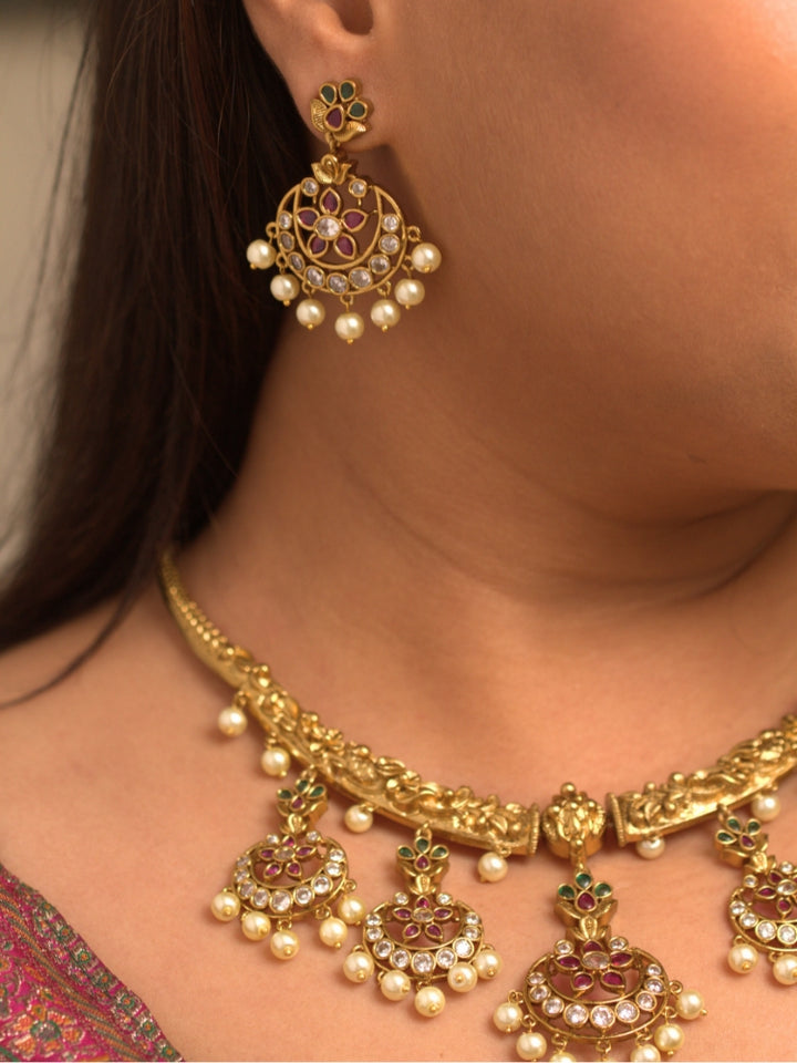 Close-up of a women wearing an ornate traditional (Gold Polish) Hasli Collar Jewellery Set and Earrings with American Diamond, Colored Stones and Pearls. Woman wearing lightweight artificial American Diamond Hasli jewelry for long wedding functions. Woman wearing Hasli American Diamond artificial jewelry for a grand celebration.