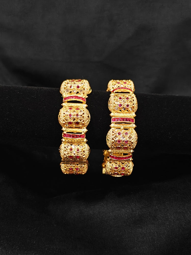 Close-up of an ornate traditional Rajwadi gold Bangle with Pink Colored Stone and Meenakari. Luxury artificial Rajwadi bangles styled for a wedding function. Close-up of artificial  Rajwadi and Meenakari bangles with detailed design.