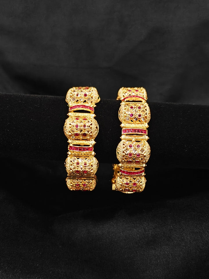 Close-up of an ornate traditional Rajwadi gold Bangle with Pink Colored Stone and Meenakari. Luxury artificial Rajwadi bangles styled for a wedding function. Close-up of artificial  Rajwadi and Meenakari bangles with detailed design.