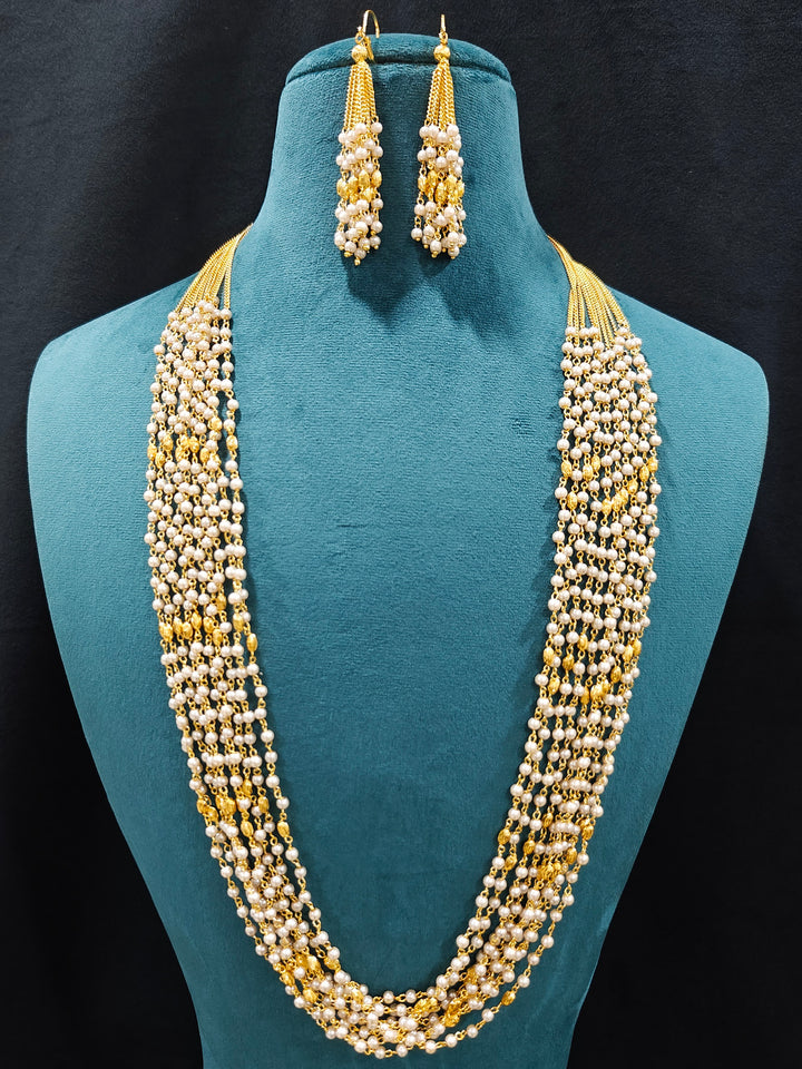 Close-up of an ornate traditional White Pearl Long Jewellery Set and Earrings with Pearl. Mehendi function outfit styled with a lightweight Pearl necklace. Festive saree look completed with a handcrafted Pearl necklace.