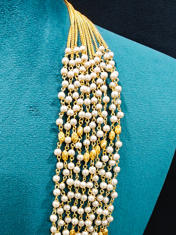 Close-up of an ornate traditional White Pearl Long Jewellery Set and Earrings with Pearl. Mehendi function outfit styled with a lightweight Pearl necklace. Festive saree look completed with a handcrafted Pearl necklace.