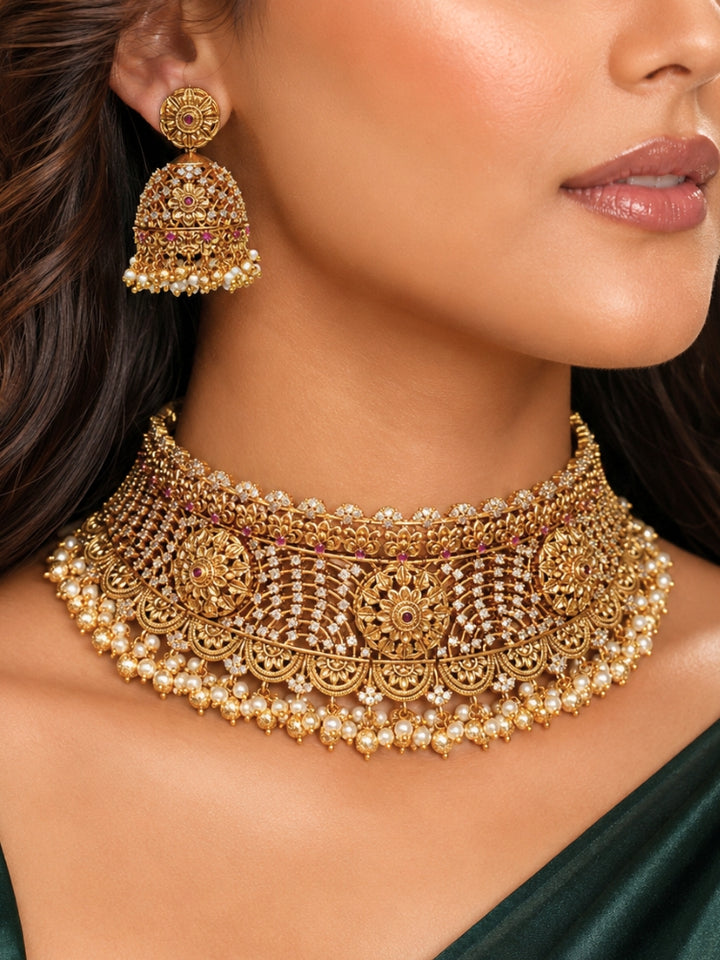 Close-up of a women wearing an ornate traditional (Gold Polish) Choker jewellery set and earrings with Pearls, American Diamond, Colored Stones. Wedding guest outfit enhanced with elegant artificial American Diamond jewelry Set. Close-up shot of a high-quality American diamond artificial necklace worn for festive celebrations.