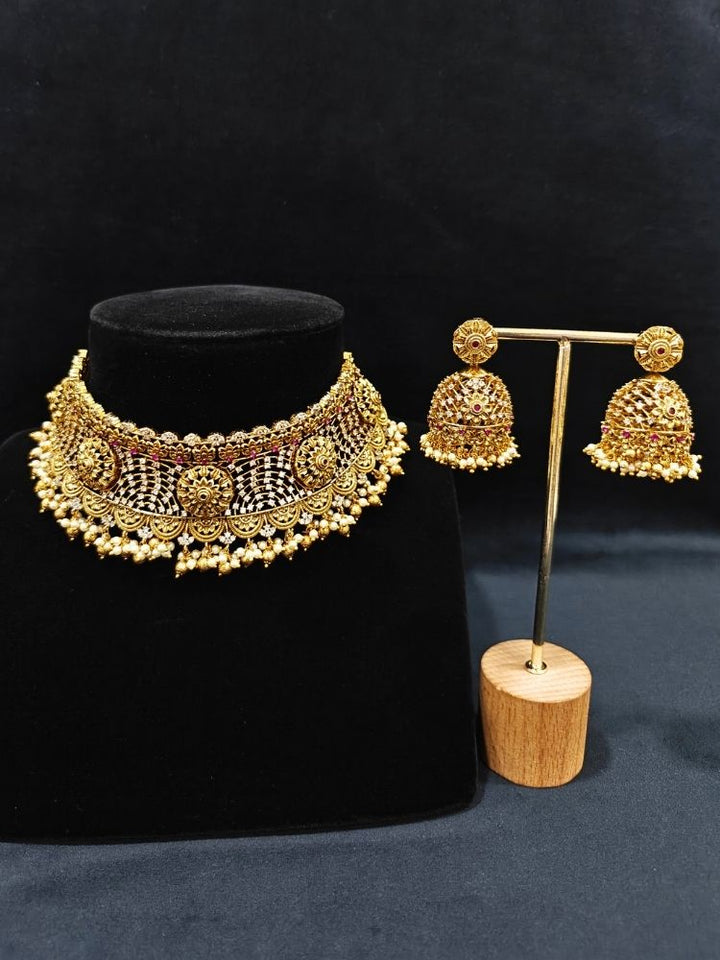 Close-up of an ornate traditional (Gold Polish) Choker jewellery set and earrings with Pearls, American Diamond, Colored Stones. Wedding guest outfit enhanced with elegant artificial American Diamond jewelry Set. Close-up shot of a high-quality American diamond artificial necklace worn for festive celebrations.