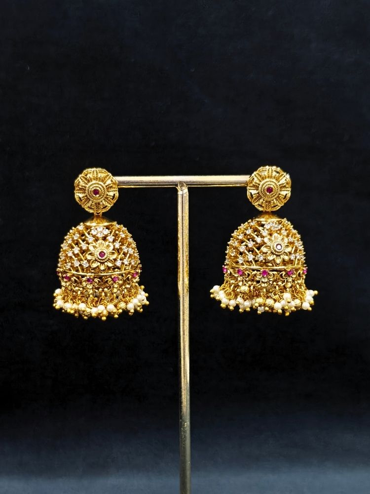 Close-up of an ornate traditional (Gold Polish) Choker jewellery set and earrings with Pearls, American Diamond, Colored Stones. Wedding guest outfit enhanced with elegant artificial American Diamond jewelry Set. Close-up shot of a high-quality American diamond artificial necklace worn for festive celebrations.