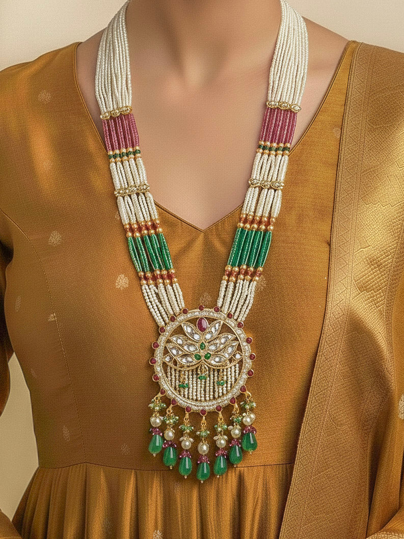 Close-up of a woman wearing an ornate traditional Mint Pink and Green Rajwadi gold Long jewellery set and earrings  with Pearls, Moissanite Kundan, Bandhai Work, Hydro Crystals and Tumble Beads. Mehendi ceremony look styled with a Rajwadi artificial jewelry set. Traditional Indian look featuring a Rajwadi necklace set.