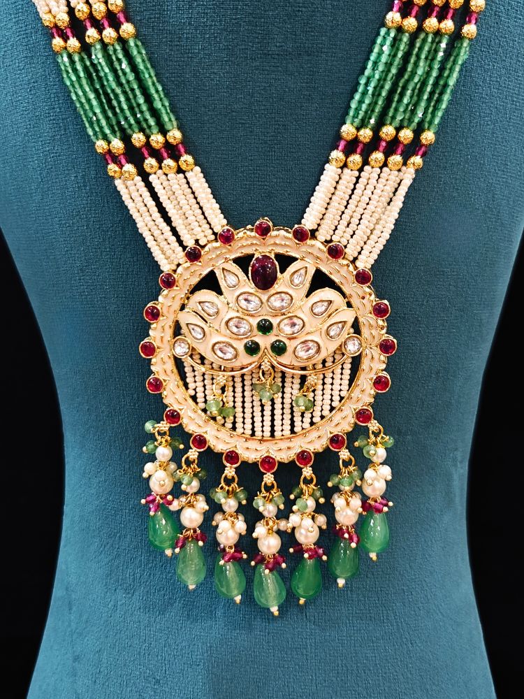 Close-up of an ornate traditional Mint Pink and Green Rajwadi gold Long jewellery set and earrings  with Pearls, Moissanite Kundan, Bandhai Work, Hydro Crystals and Tumble Beads. Mehendi ceremony look styled with a Rajwadi artificial jewelry set. Traditional Indian look featuring a Rajwadi necklace set.