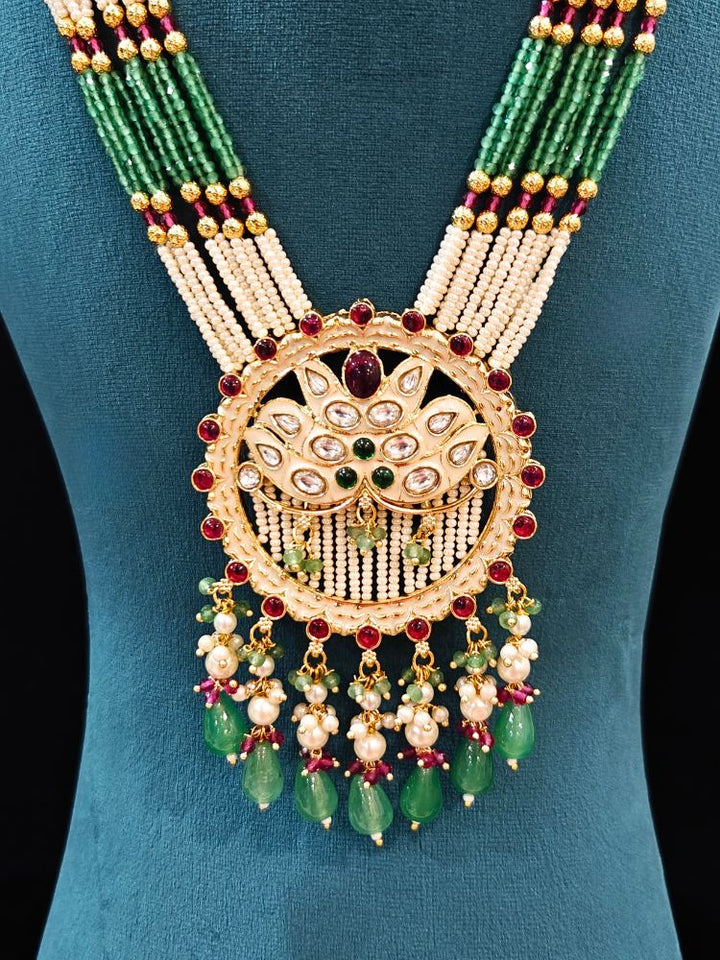 Close-up of an ornate traditional Mint Pink and Green Rajwadi gold Long jewellery set and earrings  with Pearls, Moissanite Kundan, Bandhai Work, Hydro Crystals and Tumble Beads. Mehendi ceremony look styled with a Rajwadi artificial jewelry set. Traditional Indian look featuring a Rajwadi necklace set.