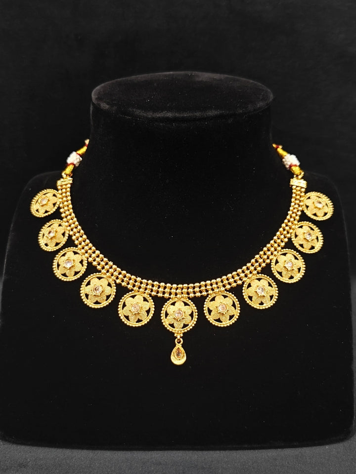 Close-up of an ornate traditional (Gold Polish) Collar jewellery set and earrings with American Diamond. Saree look completed with elegant artificial American Diamond jewelry for festive occasions. Woman wearing trending artificial American Diamond jewelry for wedding season in India.