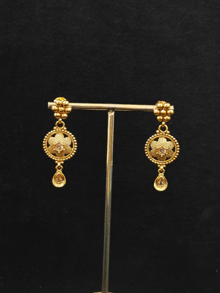 Close-up of an ornate traditional (Gold Polish) Collar jewellery set and earrings with American Diamond. Saree look completed with elegant artificial American Diamond jewelry for festive occasions. Woman wearing trending artificial American Diamond jewelry for wedding season in India.