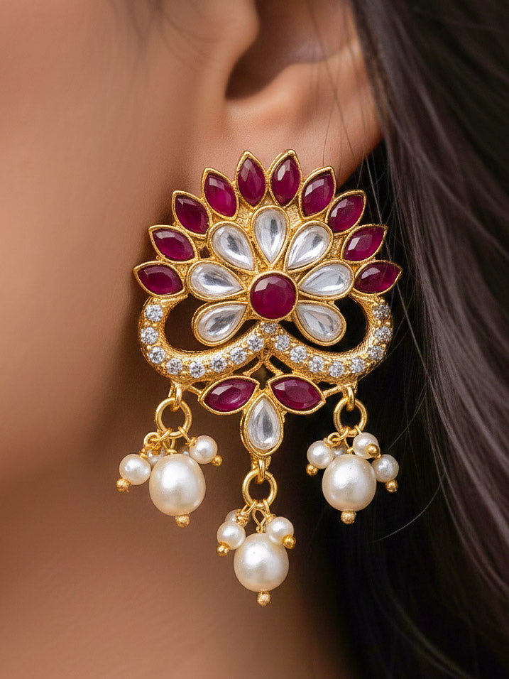 Close-up of a woman wearing an ornate traditional Red & White Layered Jewellery set and Earring with Kundan, Colored Stones, Pearls and Crystal Beads. Mehendi ceremony look completed with a handcrafted Pearl jewelry set. Mehendi ceremony look completed with a handcrafted Pearl jewelry set.