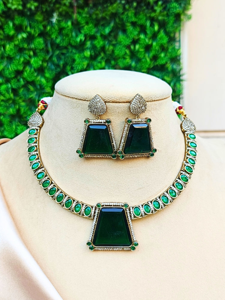 A mannequin showcasing a green necklace set with emerald stones and American diamonds, paired with matching earrings. perfect for wedding guests and formal events. This luxury artificial diamond jewelry provides the brilliance of real diamonds at a fraction of the cost.