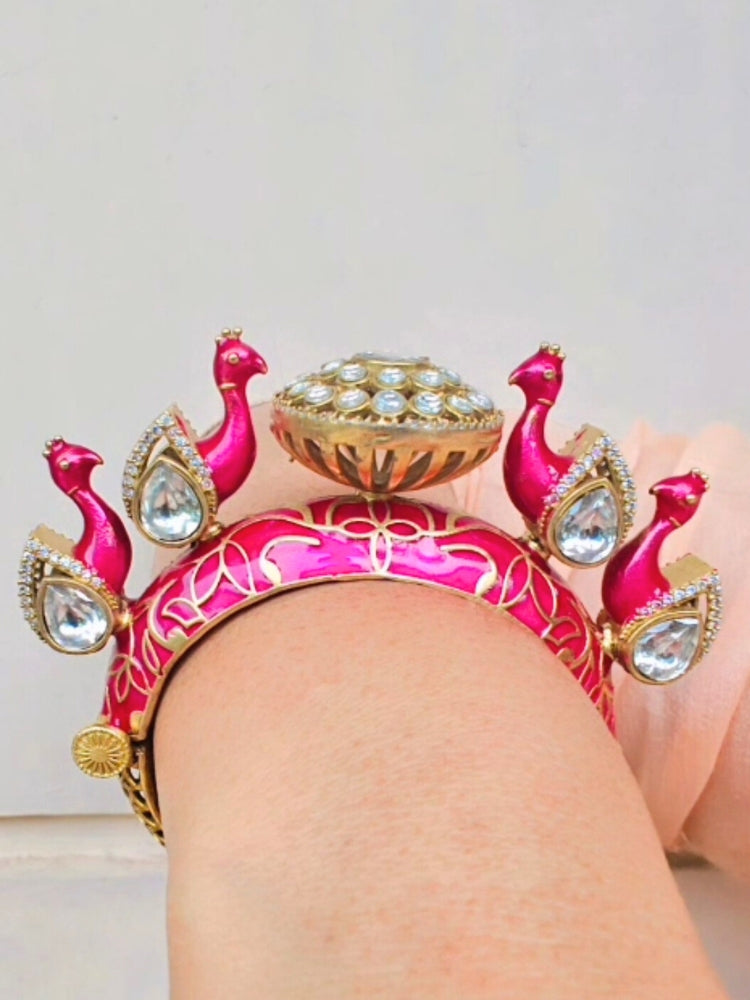 Close-up of a woman wearing an ornate traditional Pink Meenakari Bracelet with Meenakari, American Diamond and Kundan. Woman wearing a vibrant Meenakari artificial jewelry set for celebrations. Close-up of enamel work in Meenakari artificial wedding jewelry.