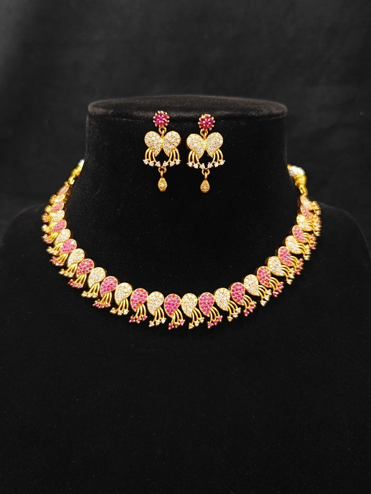 Close-up of an ornate Traditional Pink & White (Gold Polish)  Collar Necklace Set and earrings with American Diamonds and Colored Stones. Mehendi function outfit styled with a lightweight Diamond necklace. Wedding guest styling a statement American Diamond artificial necklace.
