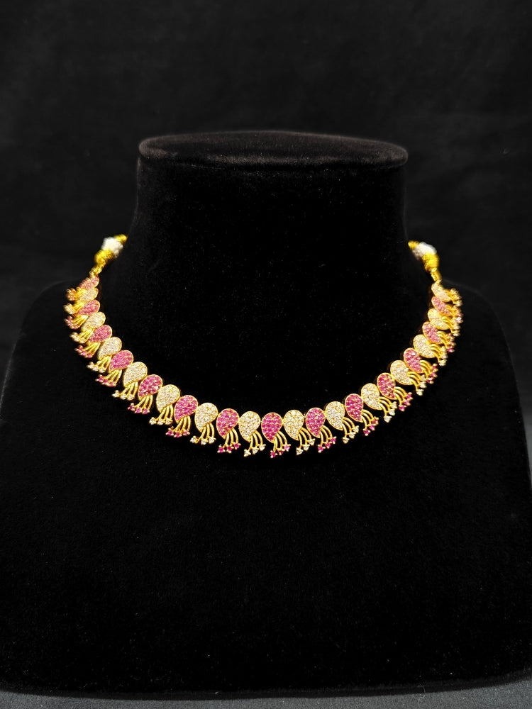 Close-up of an ornate Traditional Pink & White (Gold Polish)  Collar Necklace Set and earrings with American Diamonds and Colored Stones. Mehendi function outfit styled with a lightweight Diamond necklace. Wedding guest styling a statement American Diamond artificial necklace.