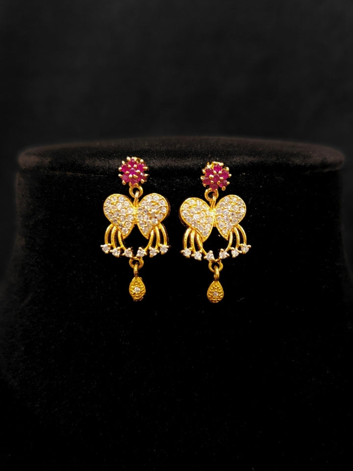 Close-up of an ornate Traditional Pink & White (Gold Polish)  Collar Necklace Set and earrings with American Diamonds and Colored Stones. Mehendi function outfit styled with a lightweight Diamond necklace. Wedding guest styling a statement American Diamond artificial necklace.