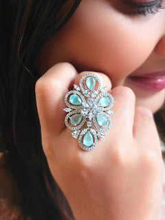 Close-up of a woman wearing an ornate Western (Silver Polish) Mint Green Ring with American Dimonds and Mint Green Colored Stones. Close-up of a cocktail party look featuring a premium American diamond Ring. Reception-ready look featuring a statement American diamond Ring.