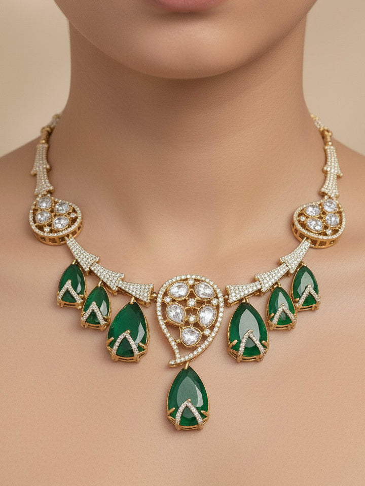 "A woman in a traditional saree, wearing a gorgeous artificial diamond, polki and green colored stone and necklace paired with diamond earrings. This artificial diamond jewelry set offers a traditional yet modern touch for Indian brides, designed to add elegance and sophistication to any occasion."
