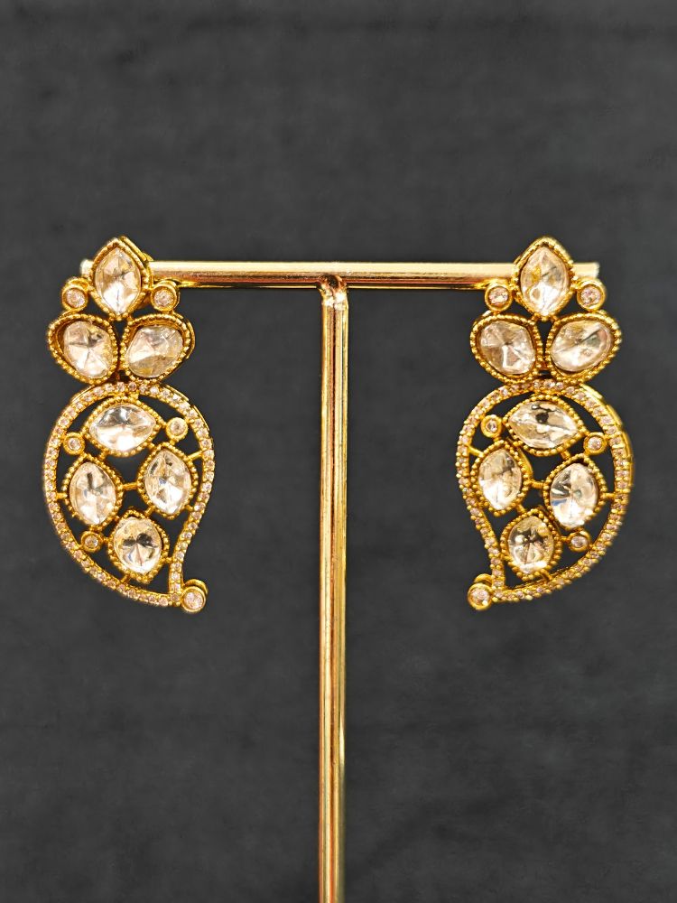 Close-up of an ornate traditional American Diamond gold Collar Red jewellery set and earrings with Red Colored Stones and American Diamond. Close-up of a featuring an anti-tarnish American diamond artificial necklace. Perfect American Diamond necklace set for weddings and festivals.