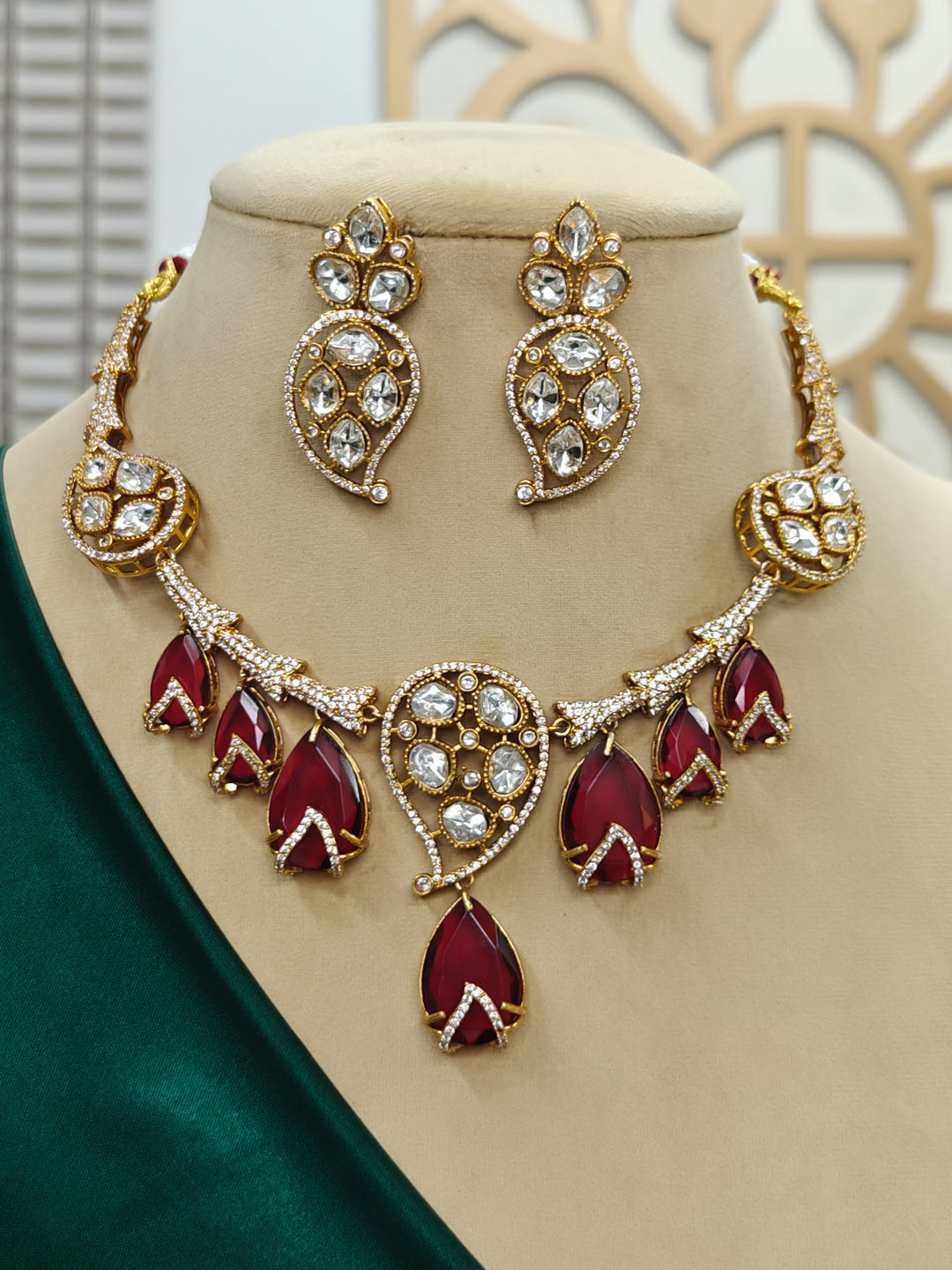 "Close-up of a woman wearing a sparkling artificial diamond and red colored stone necklace and diamond earrings set, designed to offer a radiant, elegant look for any formal occasion or Indian wedding. This affordable diamond jewelry provides a flawless, luxurious alternative to natural diamonds."
