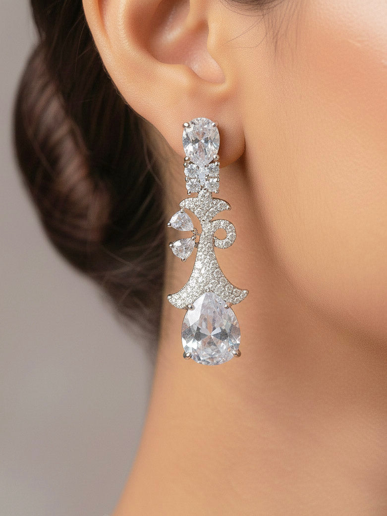 Close-up of a woman wearing an ornate Western White (Silver Polish) Collar jewellery set and earrings with American Diamonds. Close-up of a cocktail party look featuring a premium American diamond necklace. Party wear outfit completed with a lightweight American diamond necklace.