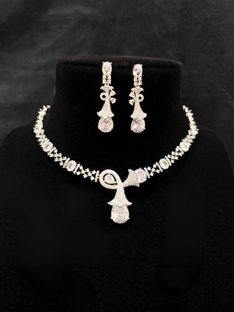 Close-up of an ornate Western White (Silver Polish) Collar jewellery set and earrings with American Diamonds. Close-up of a cocktail party look featuring a premium American diamond necklace. Party wear outfit completed with a lightweight American diamond necklace.