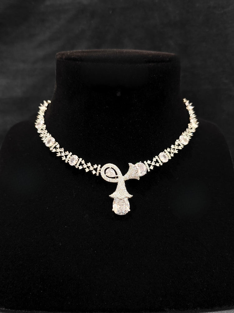 Close-up of an ornate Western White (Silver Polish) Collar jewellery set and earrings with American Diamonds. Close-up of a cocktail party look featuring a premium American diamond necklace. Party wear outfit completed with a lightweight American diamond necklace.
