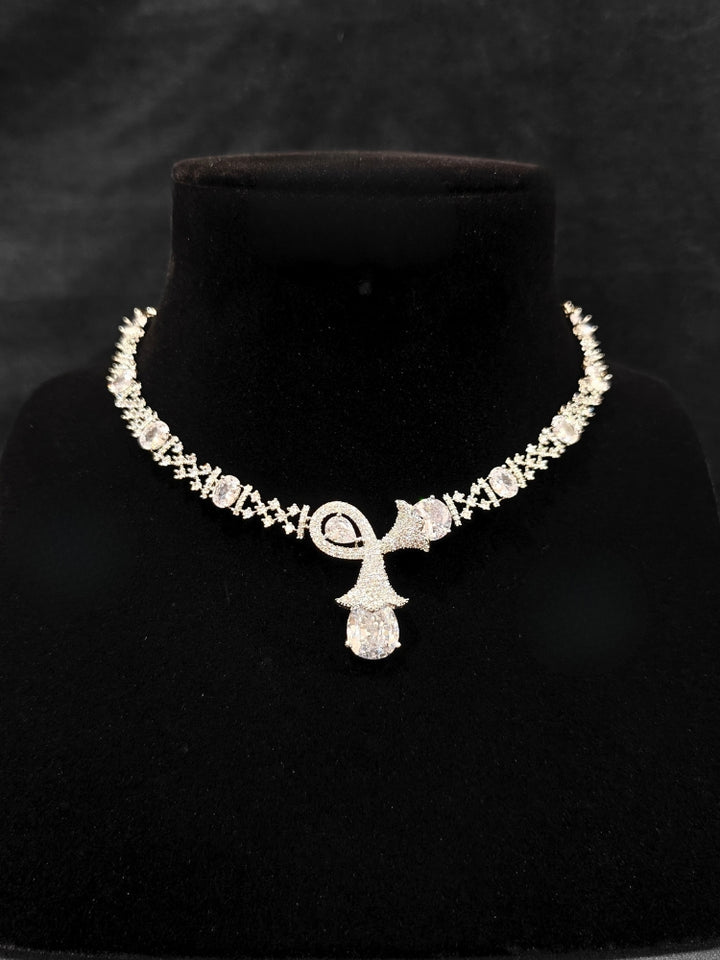 Close-up of an ornate Western White (Silver Polish) Collar jewellery set and earrings with American Diamonds. Close-up of a cocktail party look featuring a premium American diamond necklace. Party wear outfit completed with a lightweight American diamond necklace.