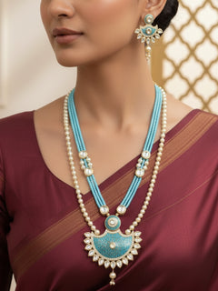 Close-up of a woman wearing an ornate traditional Mint Blue Meenakari Long  jewellery set and earrings with Kundan, Meenakari work, crystal beads, pearls and American Diamond. Saree styling inspiration with a Long Meenakari jewelry piece. Close-up of enamel work in Meenakari artificial wedding jewelry.