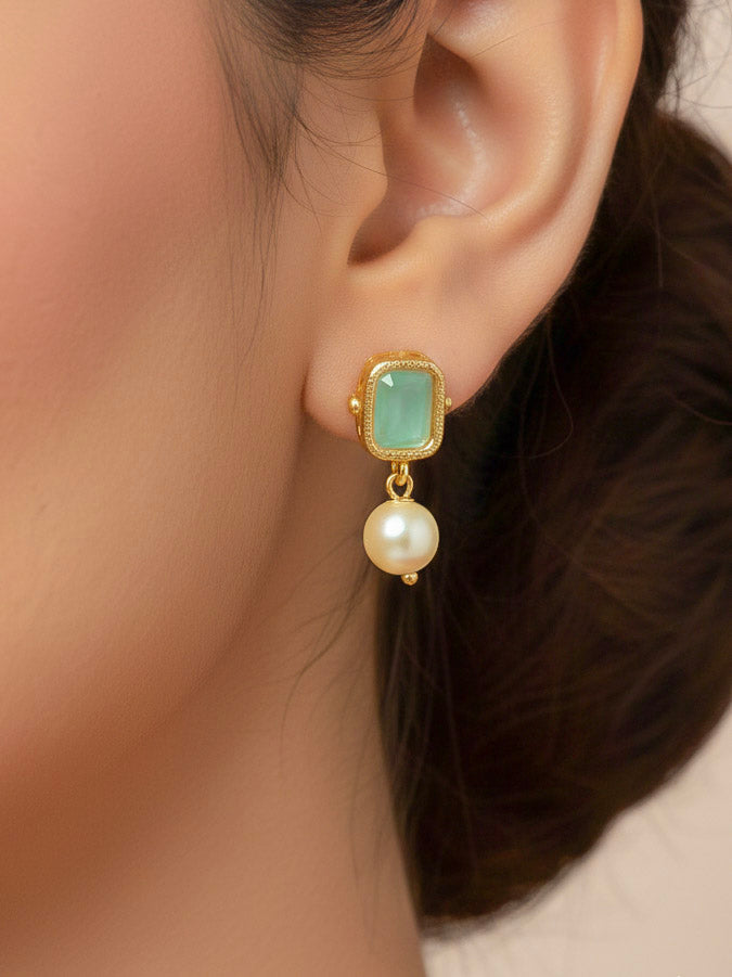 Close-up of a woman wearing an ornate traditional (Gold Polish) Mint Green Choker jewellery set and earrings with Colored Stones, Pearl and American Diamonds. Festive Diwali outfit styled with an Colored Stones artificial necklace. Mehendi function outfit styled with a Colored Stone  necklace set.