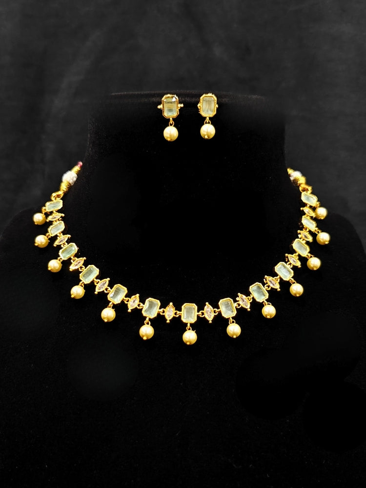 Close-up of an ornate traditional (Gold Polish) Mint Green Choker jewellery set and earrings with Colored Stones, Pearl and American Diamonds. Festive Diwali outfit styled with an Colored Stones artificial necklace. Mehendi function outfit styled with a Colored Stone  necklace set.