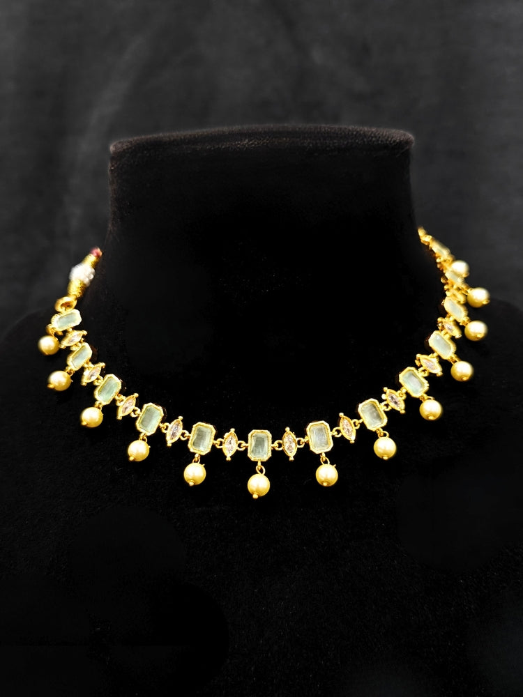 Close-up of an ornate traditional (Gold Polish) Mint Green Choker jewellery set and earrings with Colored Stones, Pearl and American Diamonds. Festive Diwali outfit styled with an Colored Stones artificial necklace. Mehendi function outfit styled with a Colored Stone  necklace set.
