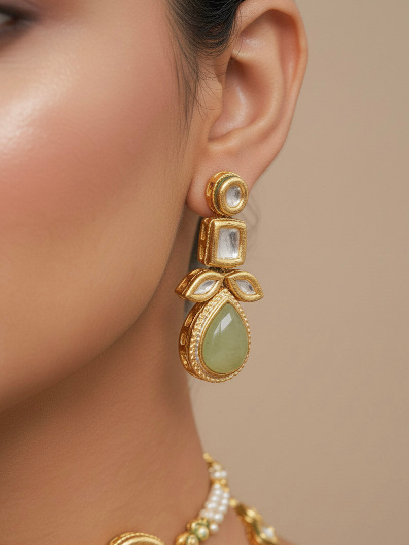 Close-up of a woman wearing an ornate traditional (Gold Polish) Mint Green Long Kundan jewellery set and earrings and a Choker and Mangtikka with Kundan and Colored Stones. Wedding celebration look enhanced with a statement Kundan necklace. Bride wearing a royal Kundan artificial necklace for wedding rituals.
