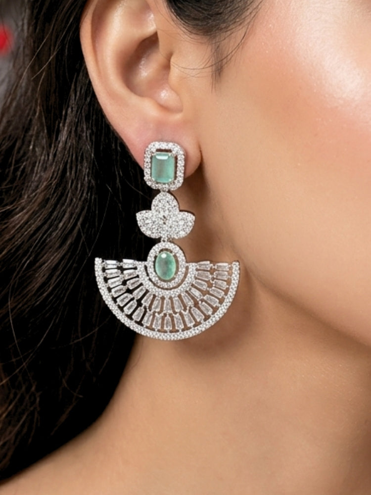 Close-up of a woman wearing an ornate Western (Silver Polish) Mint Green Diamond Earrings with American Diamond and Colored Stones. Reception-ready look featuring a statement American diamond Earrings set. Elegant wedding jewelry look featuring a premium artificial American diamond Earrings.