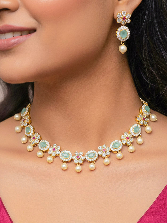 Close-up of a woman wearing an ornate traditional Mint Green (gold Polish) Collar jewellery set and earrings with American diamonds, Pearls and Colored Stones. Festive Diwali outfit styled with an American diamond artificial necklace. Elegant wedding jewelry look featuring a premium artificial American diamond necklace. 