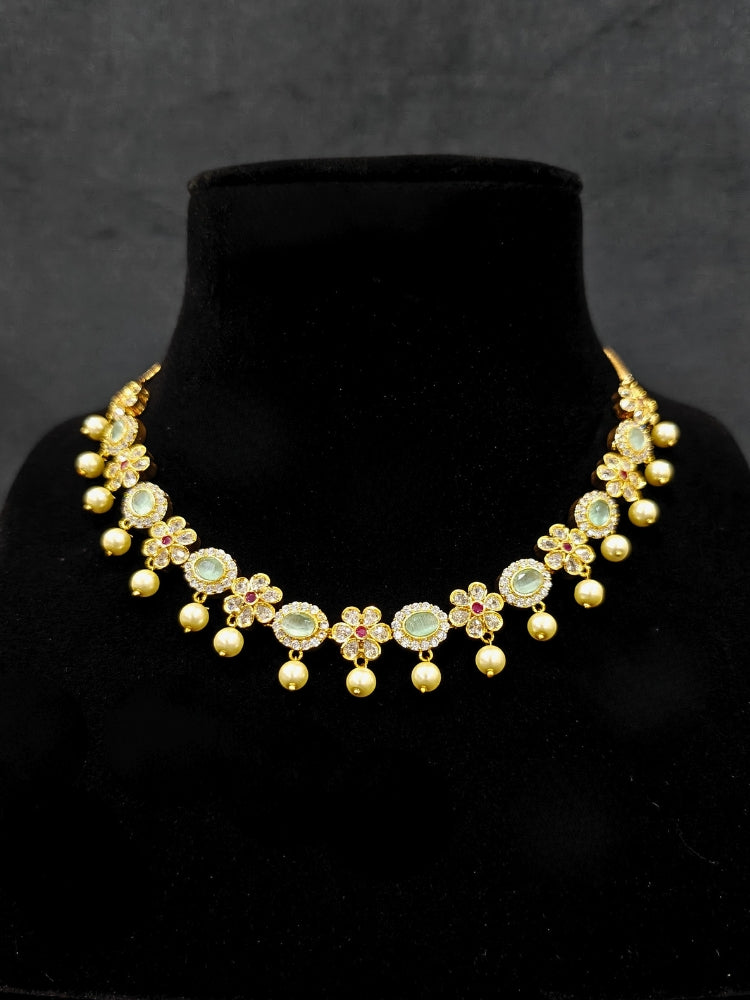 Close-up of an ornate traditional Mint Green (gold Polish) Collar jewellery set and earrings with American diamonds, Pearls and Colored Stones. Festive Diwali outfit styled with an American diamond artificial necklace. Elegant wedding jewelry look featuring a premium artificial American diamond necklace. 
