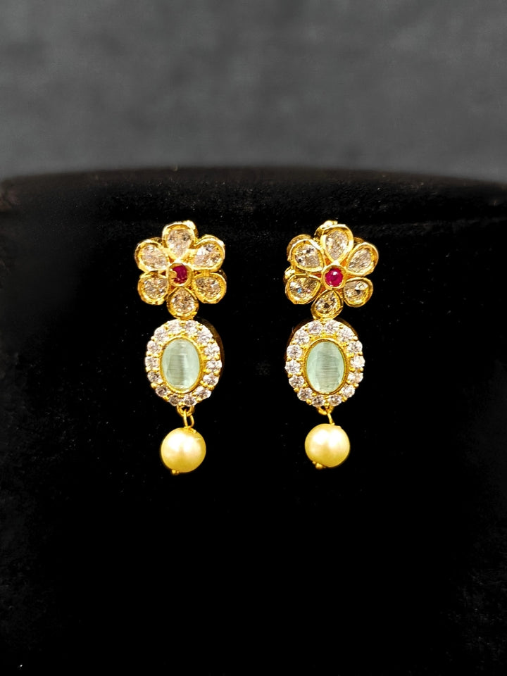 Close-up of an ornate traditional Mint Green (gold Polish) Collar jewellery set and earrings with American diamonds, Pearls and Colored Stones. Festive Diwali outfit styled with an American diamond artificial necklace. Elegant wedding jewelry look featuring a premium artificial American diamond necklace. 