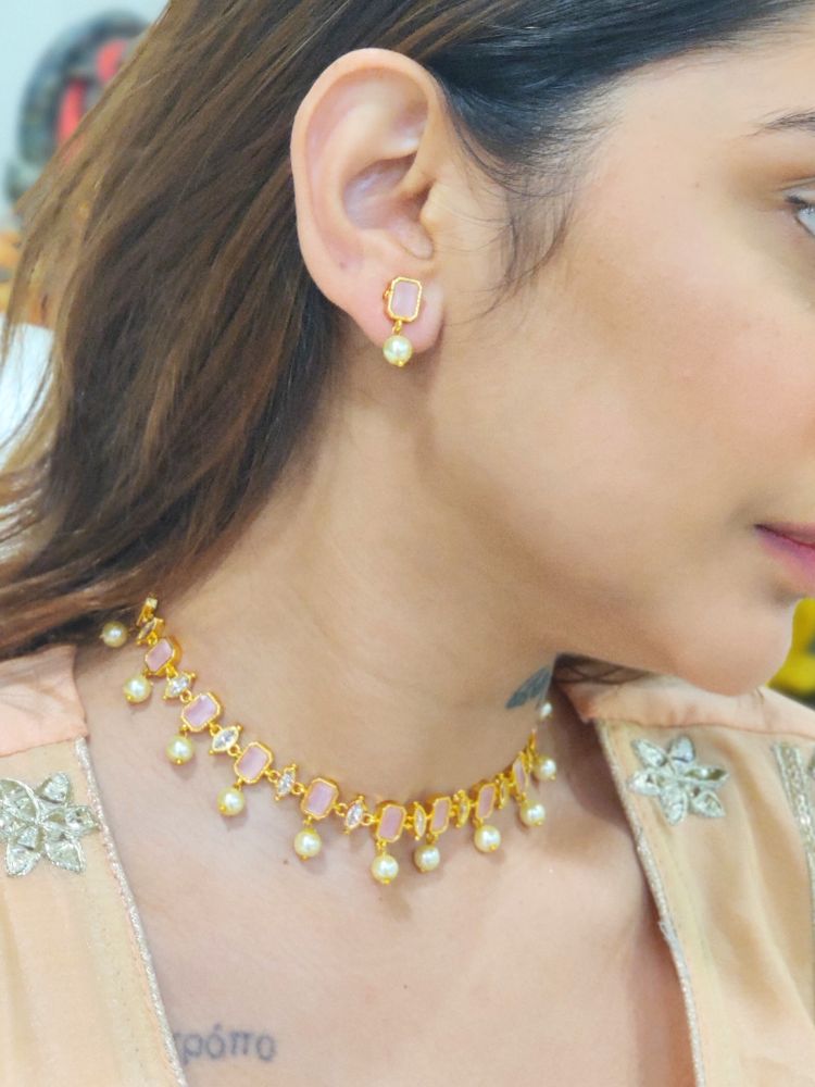 A girl looking on the side wearing The Mint Pink Amelia Choker Necklace Set features mint pink colored stones and dangling pearls, with matching stud earrings. 