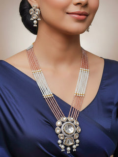 Close-up of a woman wearing an ornate traditional Mint Pink Long jewellery set and earrings with Kundan, American Diamond, pearls and Crystal Beads. Mehendi ceremony look completed with a handcrafted Kundan jewelry set. Wedding guest wearing a lightweight Kundan necklace for a Wedding function.