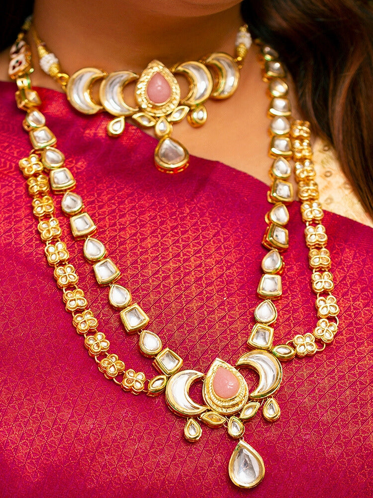 Close-up of a woman wearing an ornate traditional (Gold Polish) Mint Pink Long Kundan jewellery set and earrings and a Choker and Mangtikka with Kundan and Colored Stones. Wedding celebration look enhanced with a statement Kundan necklace. Bride wearing a royal Kundan artificial necklace for wedding rituals.