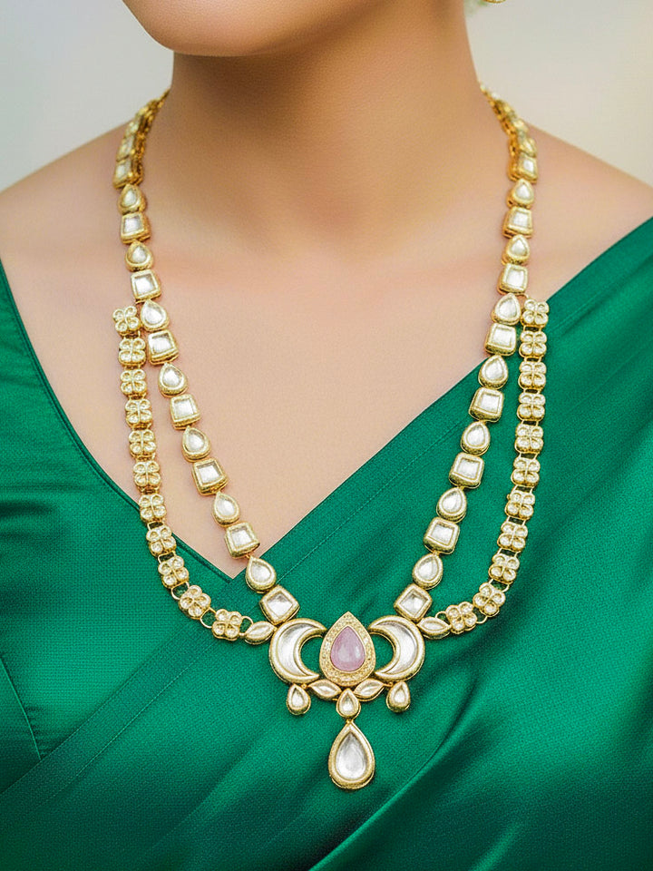 Close-up of a woman wearing an ornate traditional (Gold Polish) Mint Pink Long Kundan jewellery set and earrings and a Choker and Mangtikka with Kundan and Colored Stones. Wedding celebration look enhanced with a statement Kundan necklace. Bride wearing a royal Kundan artificial necklace for wedding rituals.