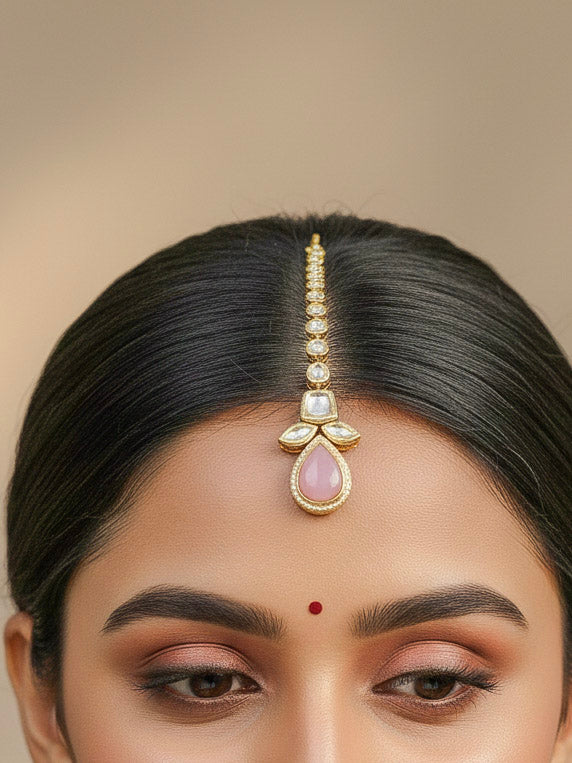 Close-up of a woman wearing an ornate traditional (Gold Polish) Mint Pink Long Kundan jewellery set and earrings and a Choker and Mangtikka with Kundan and Colored Stones. Wedding celebration look enhanced with a statement Kundan necklace. Bride wearing a royal Kundan artificial necklace for wedding rituals.