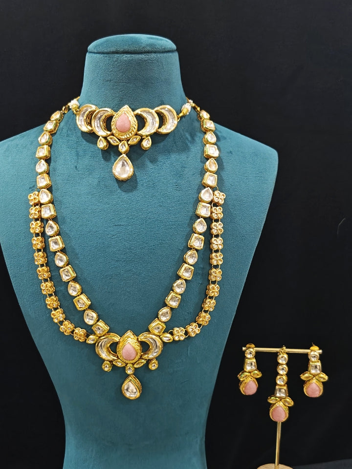 Close-up of an ornate traditional (Gold Polish) Mint Pink Long Kundan jewellery set and earrings and a Choker and Mangtikka with Kundan and Colored Stones. Wedding celebration look enhanced with a statement Kundan necklace. Bride wearing a royal Kundan artificial necklace for wedding rituals.