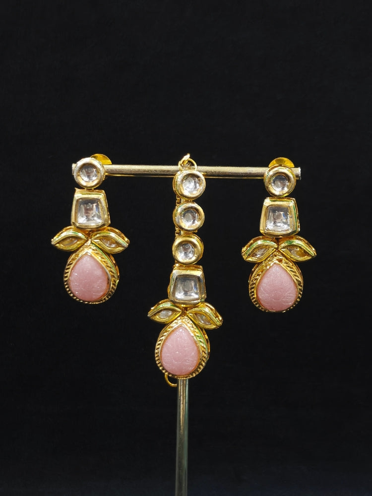 Close-up of an ornate traditional (Gold Polish) Mint Pink Long Kundan jewellery set and earrings and a Choker and Mangtikka with Kundan and Colored Stones. Wedding celebration look enhanced with a statement Kundan necklace. Bride wearing a royal Kundan artificial necklace for wedding rituals.