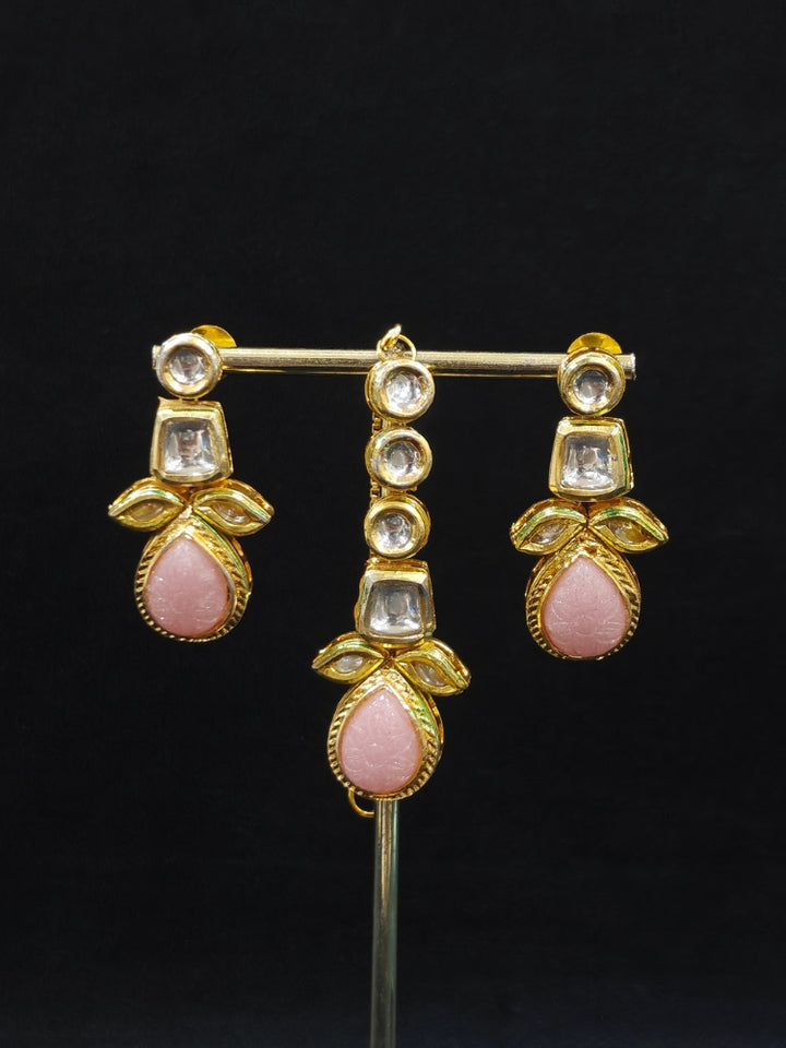 Close-up of an ornate traditional (Gold Polish) Mint Pink Long Kundan jewellery set and earrings and a Choker and Mangtikka with Kundan and Colored Stones. Wedding celebration look enhanced with a statement Kundan necklace. Bride wearing a royal Kundan artificial necklace for wedding rituals.