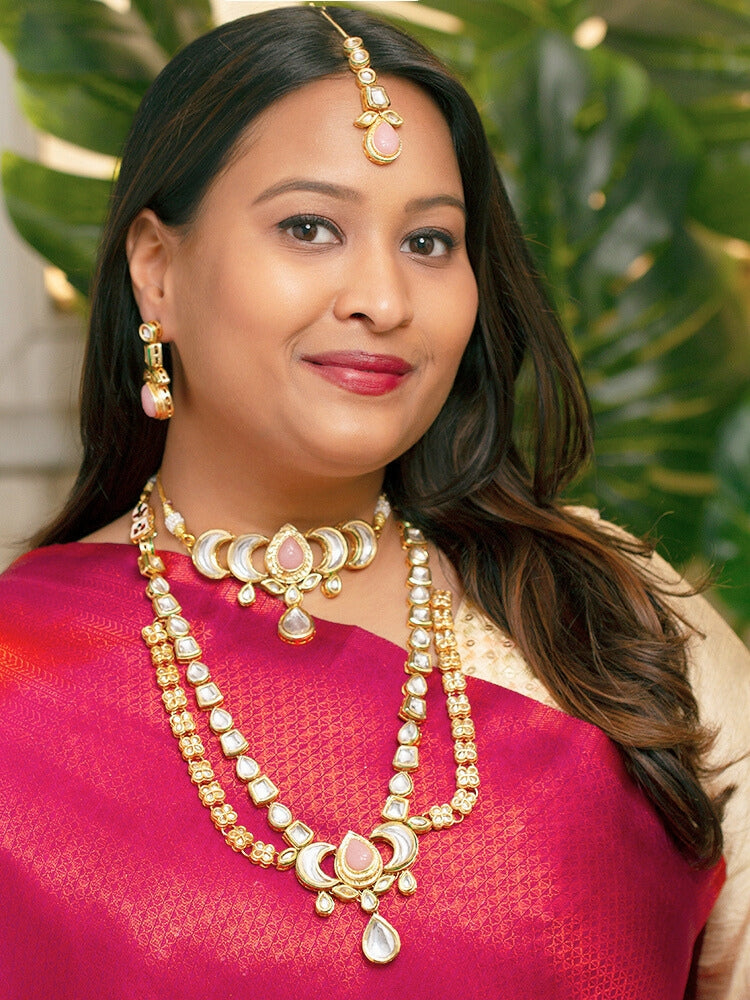 Close-up of a woman wearing an ornate traditional (Gold Polish) Mint Pink Long Kundan jewellery set and earrings and a Choker and Mangtikka with Kundan and Colored Stones. Wedding celebration look enhanced with a statement Kundan necklace. Bride wearing a royal Kundan artificial necklace for wedding rituals.