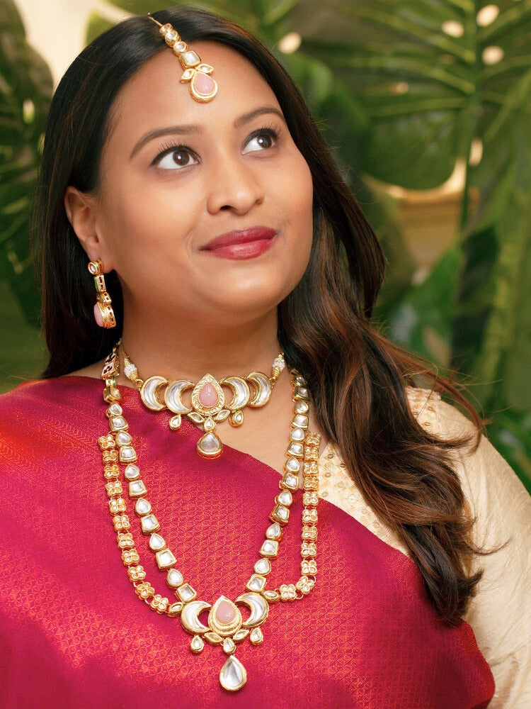 Close-up of a woman wearing an ornate traditional (Gold Polish) Mint Pink Long Kundan jewellery set and earrings and a Choker and Mangtikka with Kundan and Colored Stones. Wedding celebration look enhanced with a statement Kundan necklace. Bride wearing a royal Kundan artificial necklace for wedding rituals.