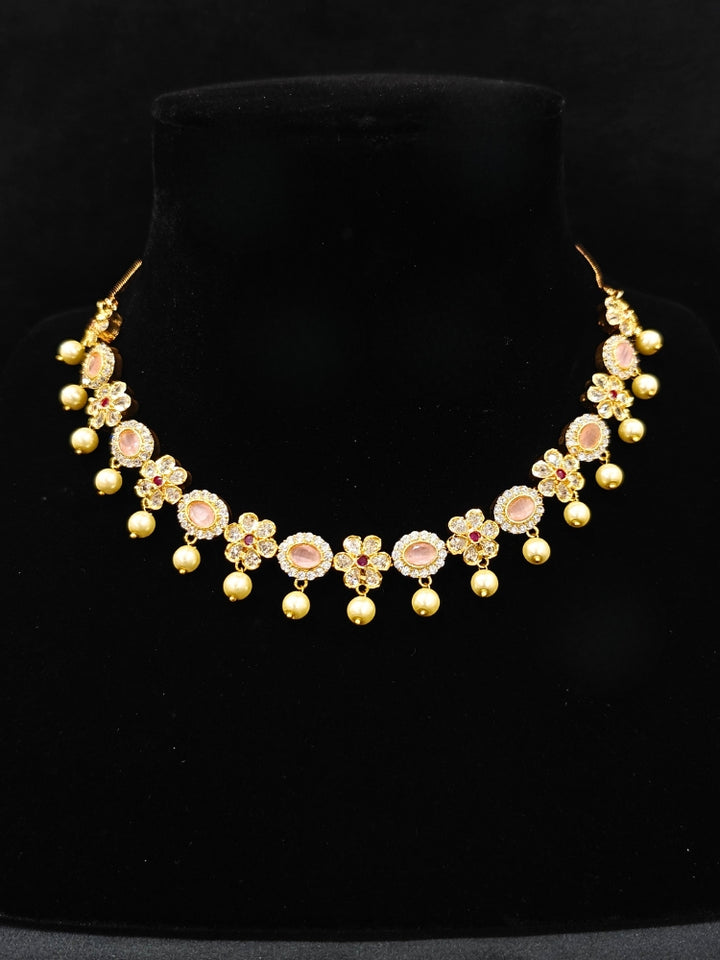 Close-up of an ornate traditional Mint Pink (gold Polish) Collar jewellery set and earrings with American diamonds, Pearls and Colored Stones. Festive Diwali outfit styled with an American diamond artificial necklace. Elegant wedding jewelry look featuring a premium artificial American diamond necklace. 